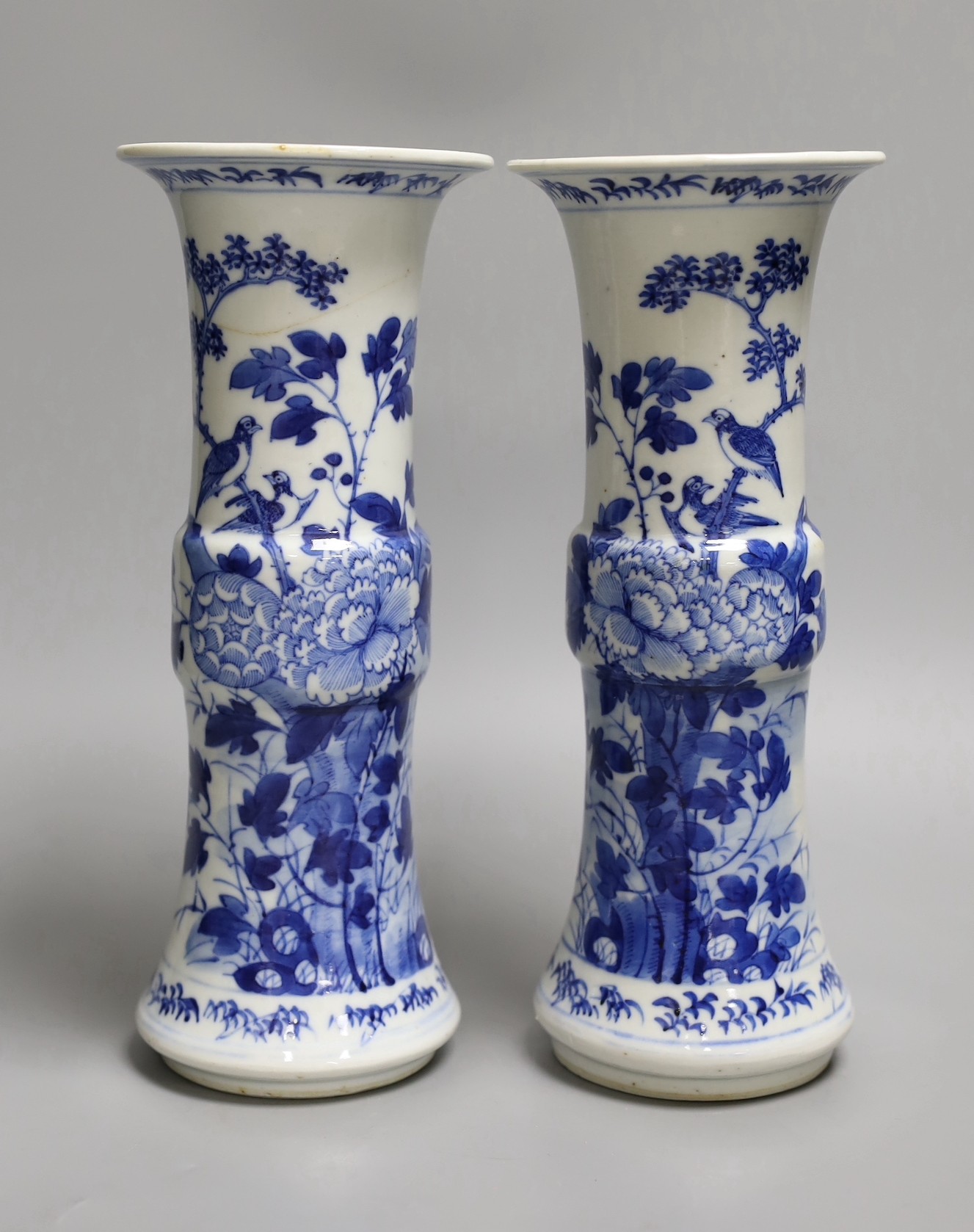 A pair of 19th century Chinese blue and white 'rockwork, birds and flowers' gu vases, 26cm